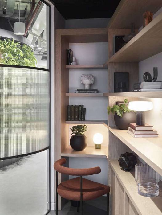 Reading corner with layered shelving and low lighting