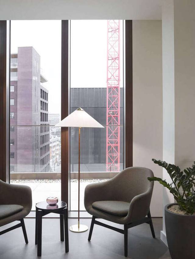 Lounge chairs beside full-height glazing