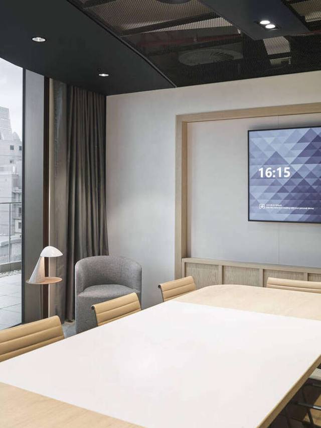 Oak-framed media wall in a meeting room, screen live