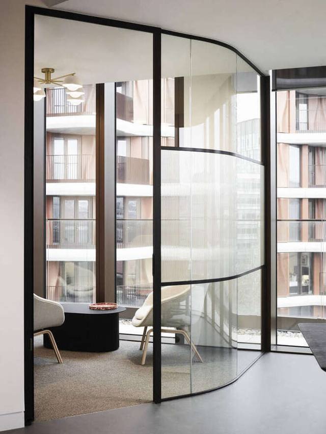 Curved fluted glazing to a quiet room, brass pendant above