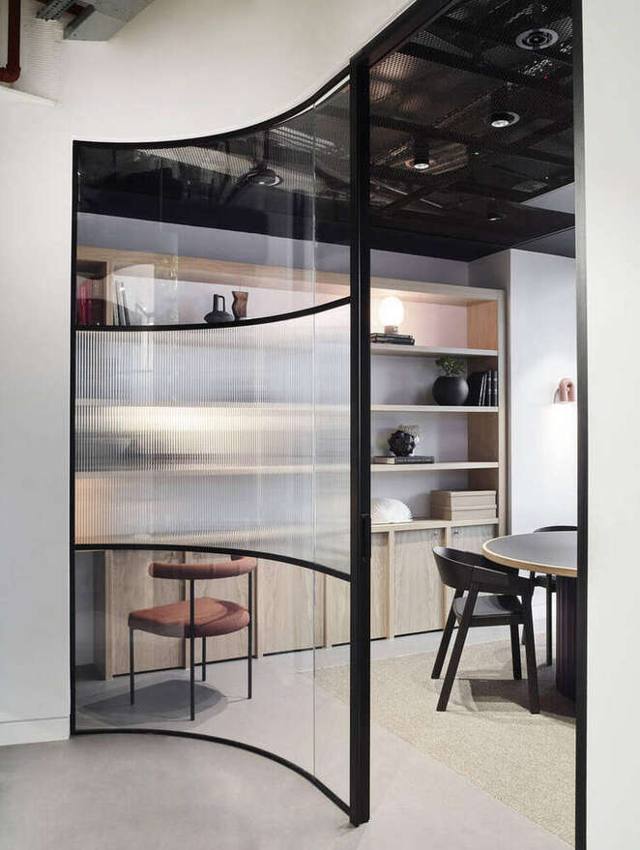 Curved fluted-glass meeting pod with round table