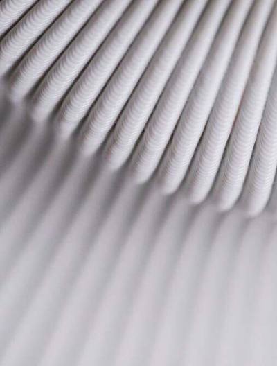 Close-up of white 3D-printed coils catching the light